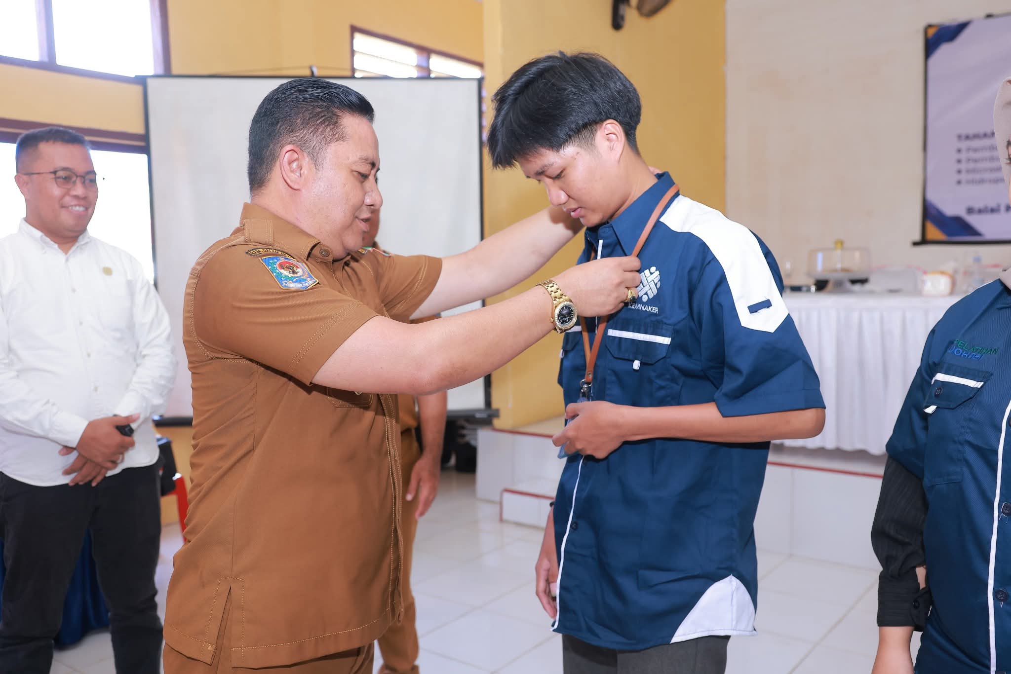 Ketgam : Wakil Bupati Bombana Ahmad Yani, S.Pd., M.Si Saat Menyamatkan Tanda Peserta Pelatihan Kewirausahaan dan Keterampilan Masyarakat Secara Simbolis di Aula Kantor Camat Rumbia Tengah, Senin 20 Oktober 2025