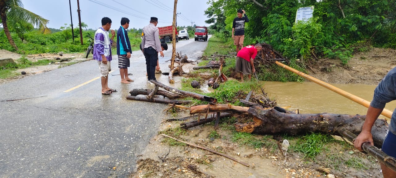 Ketgam: Kapolsek Ipda Muh. Fajar Aswan T., S.Si., SH.m., Bersama Warga Setempat Lakukan Pembersihan Jalan Pasca Banjir. Selasa 09 Desember 2025
